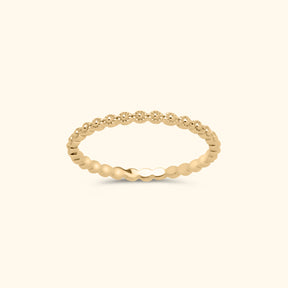 Goudkleurige stapelring van gold plated messing met een patroon van kleine bolletjes rondom de band.